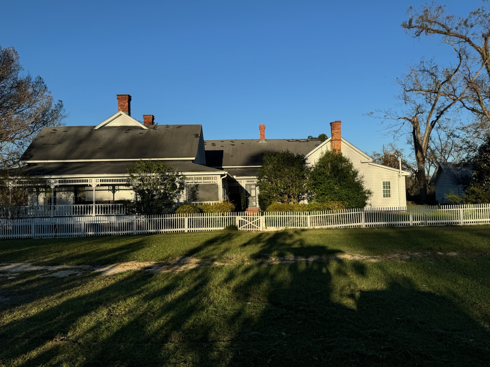 The McArthur Main House with its wraparound porch and white picket fence